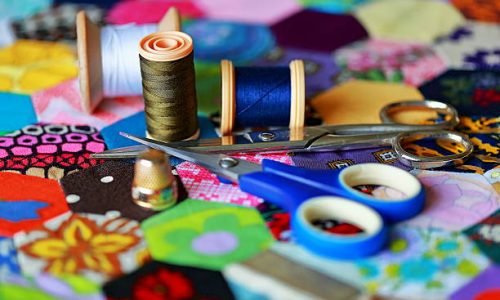 Cotton reels,thimble and scissors on a homemade patchwork quilt